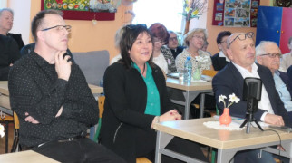 Osoby siedzą przy stolikach. Uczestnicy spotkania literackiego