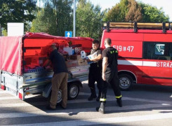 Samochód straży pożarnej i trzej mężczyźni obok niego