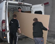 Młodzi mężczyźni podczas rozładunku darów dla powodzian 