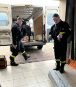 Mężczyźni ładują materiały budowlane na naczepę busa