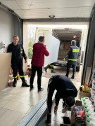 Mężczyźni podczas załadunku materiałów na naczepę busa