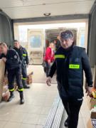 Mężczyźni podczas załadunku materiałów budowlanych na naczepę busa