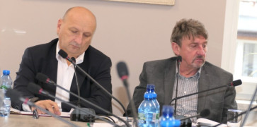 Dwaj mężczyźni siedzą obok siebie