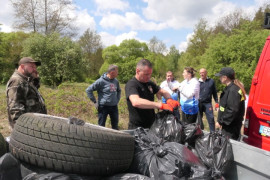 Grupa osób podczas sprzątania brzegów rzeki Warty. Widoczne są zebrane śmieci