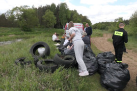 Osoby i worki, w których znajdują się śmieci zebrane podczas sprzątania brzegów rzeki Warty