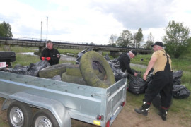 Mężczyźni i przyczepka samochodowa, na której znajdują się śmieci zebrane podczas akcji sprzątania rzeki Warty