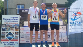 Trzej mężczyźni stoją na podium 