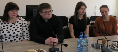 Trzy kobiety i mężczyzna siedzą przy stole 