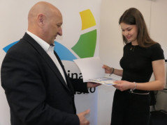 Mężczyzna wręcza dyplom dziewczynie 