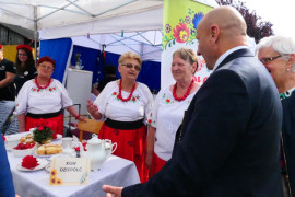 Grupa osób przy stoliku podwieczorkowym 