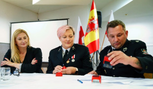 Dwie kobiety i mężczyzna siedzą przy stole. Moment podpisywania umowy 
