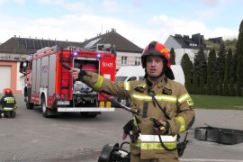 Strażak trzyma w ręku krótkofalówkę 