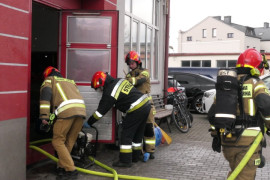 Strażacy wchodzą do budynku. Pokaz akcji ratowniczej 