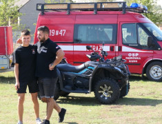 Dwaj mężczyźni stoją w pobliżu wozów strażackich 
