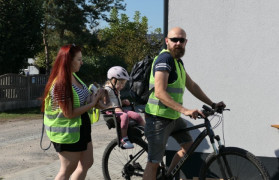 Kobieta, mężczyzna i małe dziecko. Dziecko siedzi w rowerowym foteliku 