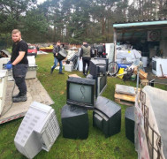 Zbiórka zużytych sprzętów. Widoczny jest mężczyzna i m.in. stare telewizory 