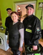 Kobieta i dwaj strażacy ochotnicy. Osoby znajdują się w pomieszczeniu 