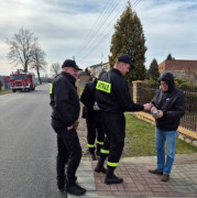 Strażacy przekazują czujkę dymu mężczyźnie 
