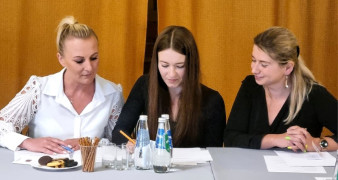 Trzy kobiety siedzące obok siebie
