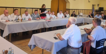 Grupa osób podczas spotkania. Wszyscy siedzą przy stole
