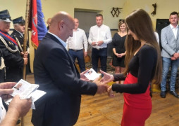 Mężczyzna wręcza legitymację kobiecie