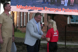Mężczyzna wręcza dziewczynce nagrodę 
