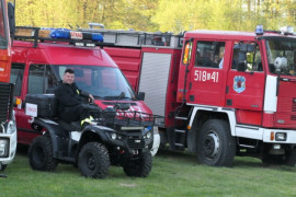 Wozy strażacki i quad. Na quadzie siedzi strażak 