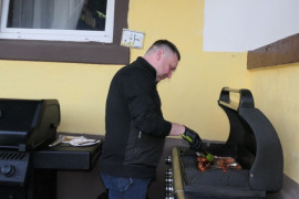 Mężczyzna podczas obsługi grilla 