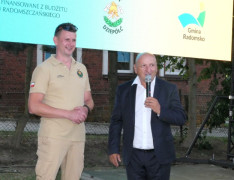 Dwaj mężczyźni stoją obok siebie. Jeden z nich przemawia 