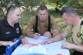 Trzech mężczyzn siedzi przy stole. Za chwilę podpisane zostaną dokumenty