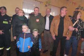 Grupa osób: kobiety, mężczyźni i dzieci stoją obok siebie