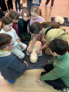 Dzieci uczestniczą w szkoleniu z zakresu pierwszej pomocy przedmedycznej. Nauka udzielania pomocy na fantomach 