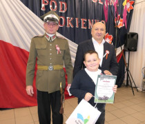 Dwaj mężczyźni i chłopiec. Chłopiec trzyma w ręku dyplom