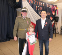 Dwaj mężczyźni i dziewczynka. Dziewczynka trzyma w ręku dyplom 