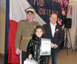 Dwaj mężczyźni i dziewczynka. Dziewczynka trzyma w ręku dypolom
