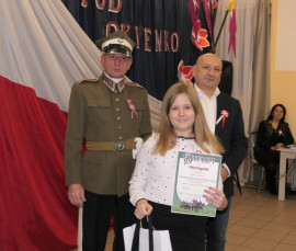 Dwaj mężczyźni i dziewczynka. Dziewczynka trzyma w ręku dyplom