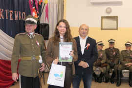 Dwaj mężczyźni i nastolatka. Nastolatka trzyma w ręku dyplom 