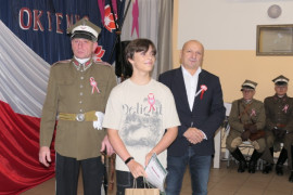 Dwaj mężczyźni i chłopiec. Chłopiec trzyma w ręku dyplom 