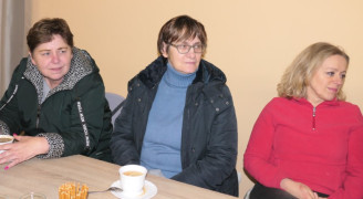 Trzy kobiety siedzą za stołem 