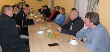 Osoby siedzą za stołem. Uczestnicy debaty