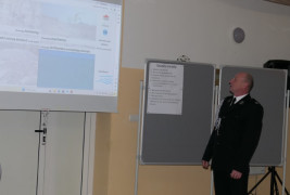 Mężczyzna w mundurze stoi przy rzutniku 