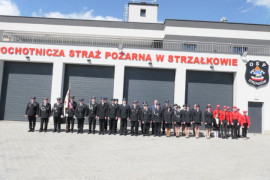 Budynek strażnicy. Przed budynkiem w dwuszeregu stoją strażacy 