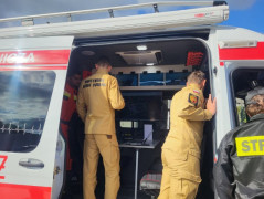 Dwaj strażacy oglądają specjalistyczny wóz strażacki 