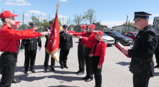 Młodzi strażacy składają przysięgę. Widoczny sztandar straży 