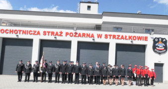 Druhny i druhowie stoją w dwuszeregu przez budynkiem strażnicy