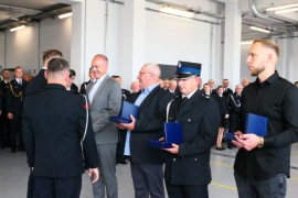 Moment wręczania podziękowań. Na zdjęciu widoczni mężczyźni 