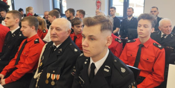 Druhowie siedzą na krzesłach 