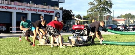 Grupa mężczyzn. Trwają przygotowania do zawodów sportowo-pożarniczych 