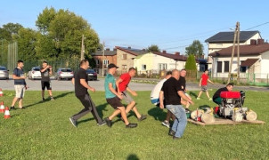 Grupa mężczyzn podczas treningu przed zawodami sportowo-pożarniczymi 