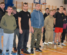 Młodzi mężczyźni stoją w dwuszeregu obok siebie
